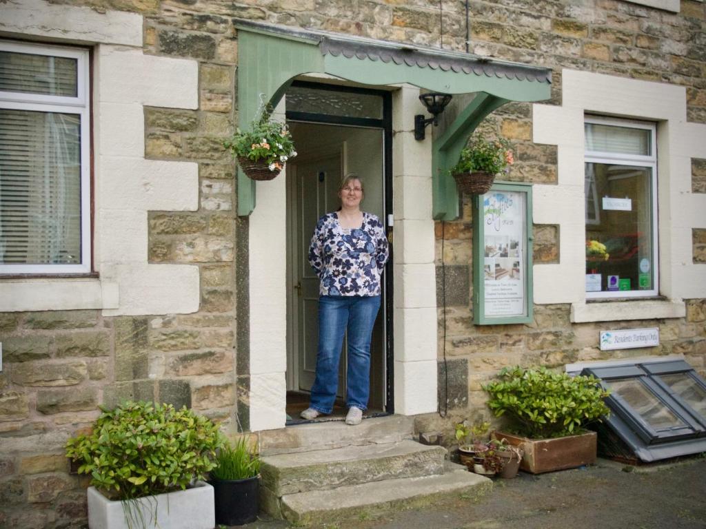 a woman standing in the doorway of a building at Shaftoe's Bed and Breakfast in Haydon Bridge