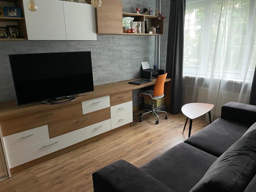 a living room with a flat screen tv on a dresser at Modern Apartment suitable for longstays in Rīga