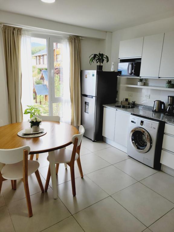 une cuisine avec une table et une table ainsi qu'une salle à manger dans l'établissement Departamento Altos de Ushuaia, à Ushuaia