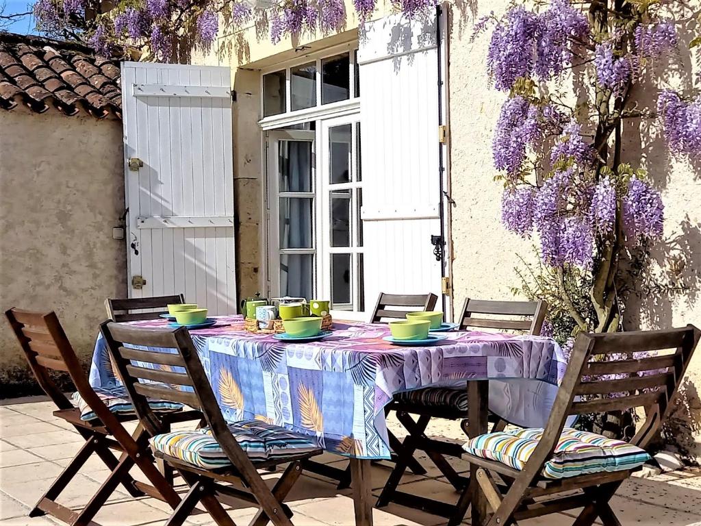 mesa con 2 sillas y mantel púrpura en l'Ecurie - La Maïsou en Sérignac