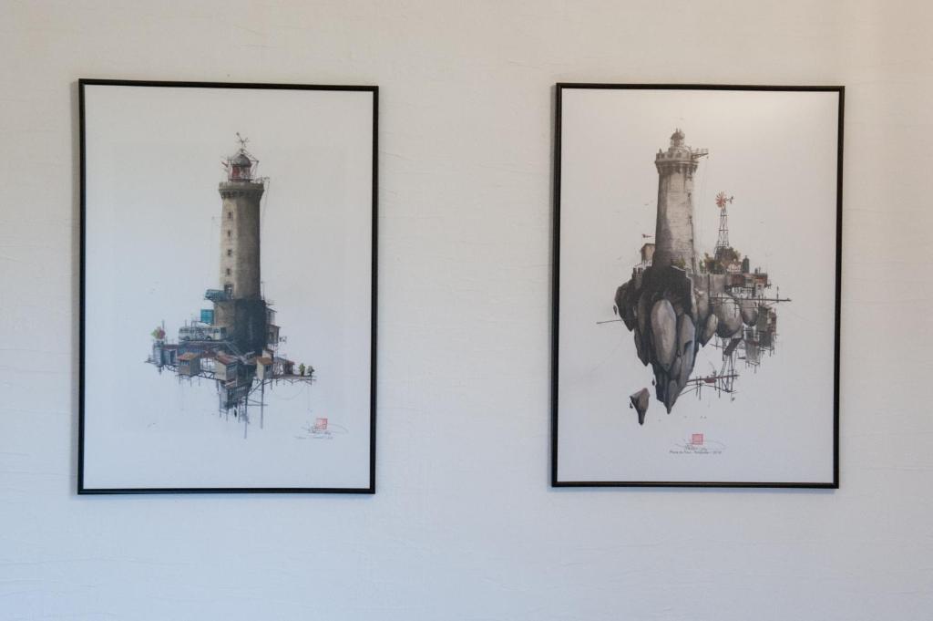 three framed pictures of three lighthouses on a wall at AR PENNITI - Magnifique maison en pierre proche plage in Landéda