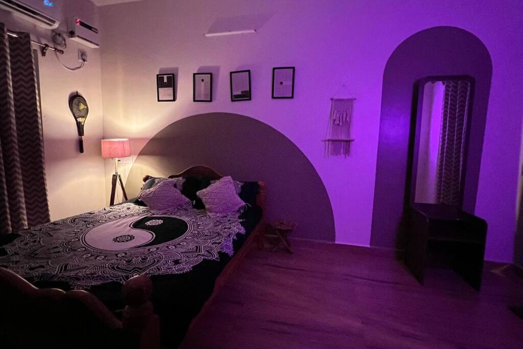ein lila Zimmer mit einem Bett und einem Tisch in der Unterkunft Wind and Wave Villa No 2, 2BHK Near Pondy Auroville Pondicherry in Marakkānam
