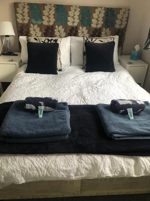 Una cama con dos toallas y dos tazas. en Little Acorns en Saint Albans