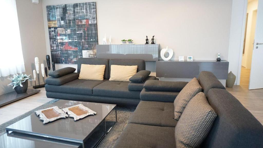 - un salon avec un canapé et une table dans l'établissement Ferienwohnung XL Komfort 8B, à Daisendorf