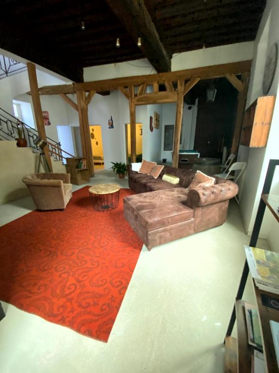 - un salon avec un canapé et un tapis rouge dans l'établissement Gîte Les Domaines, à Avallon