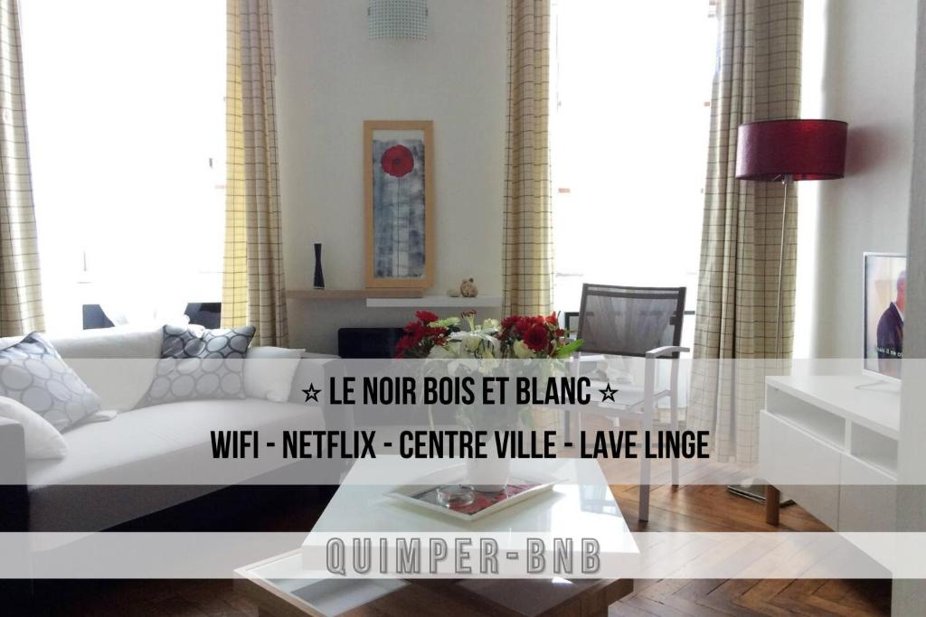 ein Wohnzimmer mit einem weißen Sofa und einem Tisch in der Unterkunft LE NOIR BOIS ET BLANC - Studio - Wifi - Centre Ville - Entrée Autonome in Quimper
