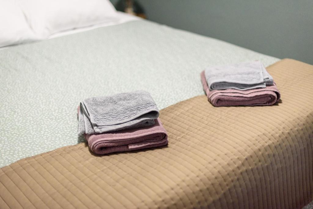 2 asciugamani sono seduti sopra un letto di Patras' Hitech Apartment a Patra