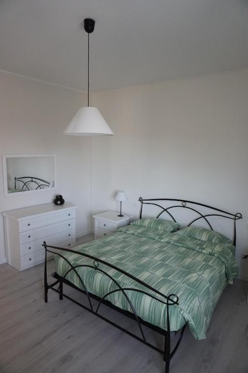 a bedroom with a bed and a white wall at Domus Anna in Montegrotto Terme