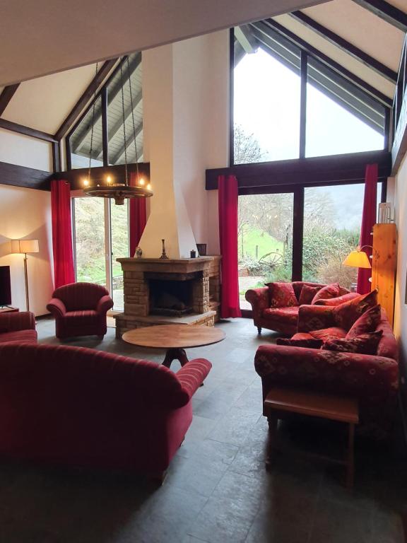 sala de estar con sofás rojos y chimenea en Großes Ferienhaus Sauerburgblick, en Sauerthal