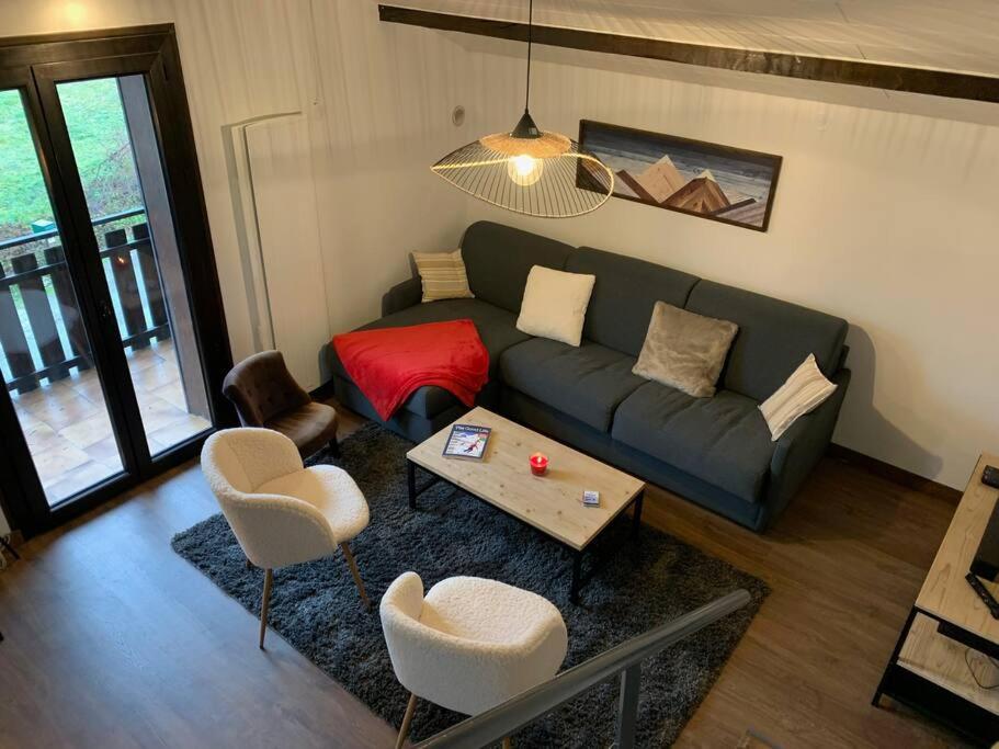 sala de estar con sofá, mesa y sillas en Duplex 3 chambres Vue Mont-Blanc, en Domancy