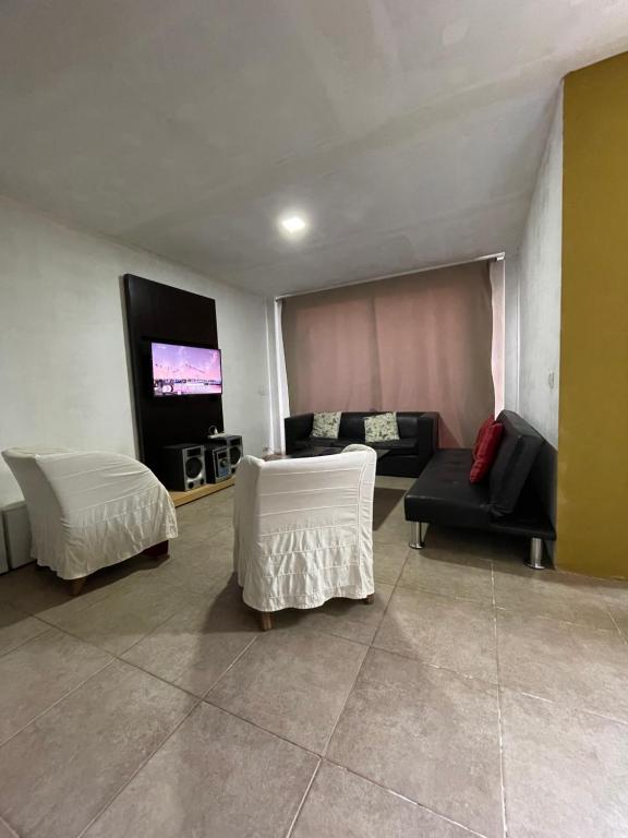 sala de estar con sofá y TV de pantalla plana en Casa en mar del plata en Mar del Plata