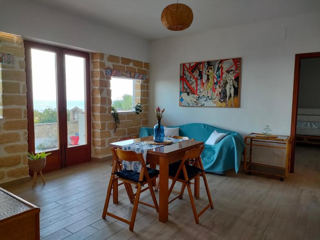 een woonkamer met een tafel en stoelen en een bank bij mdresort villa fronte mare in Trabia