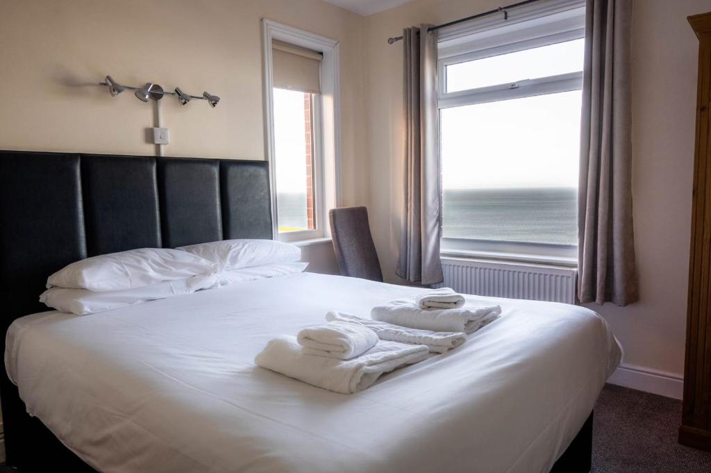 a bedroom with a bed with towels on it with a window at The Wheeldale in Whitby