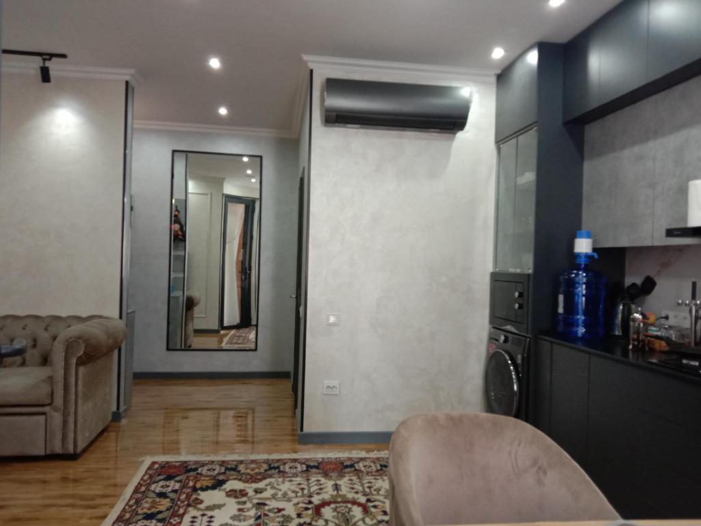 een woonkamer met een bank en een spiegel bij apartment seven A in Tasjkent