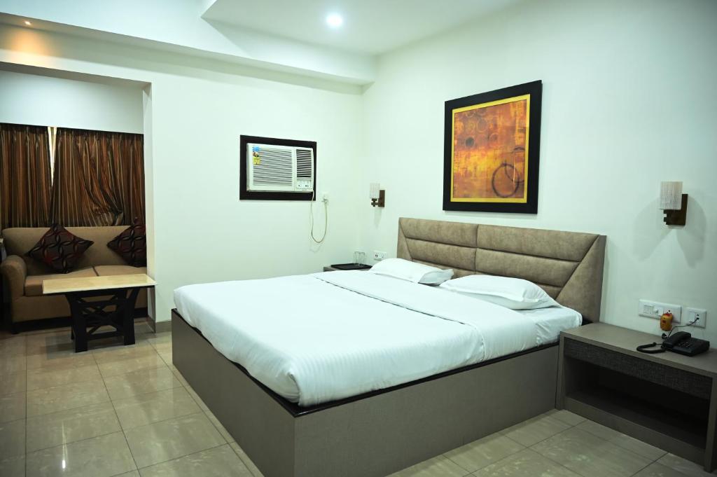 a bedroom with a large white bed in a room at ELGIN SUITES in Kolkata