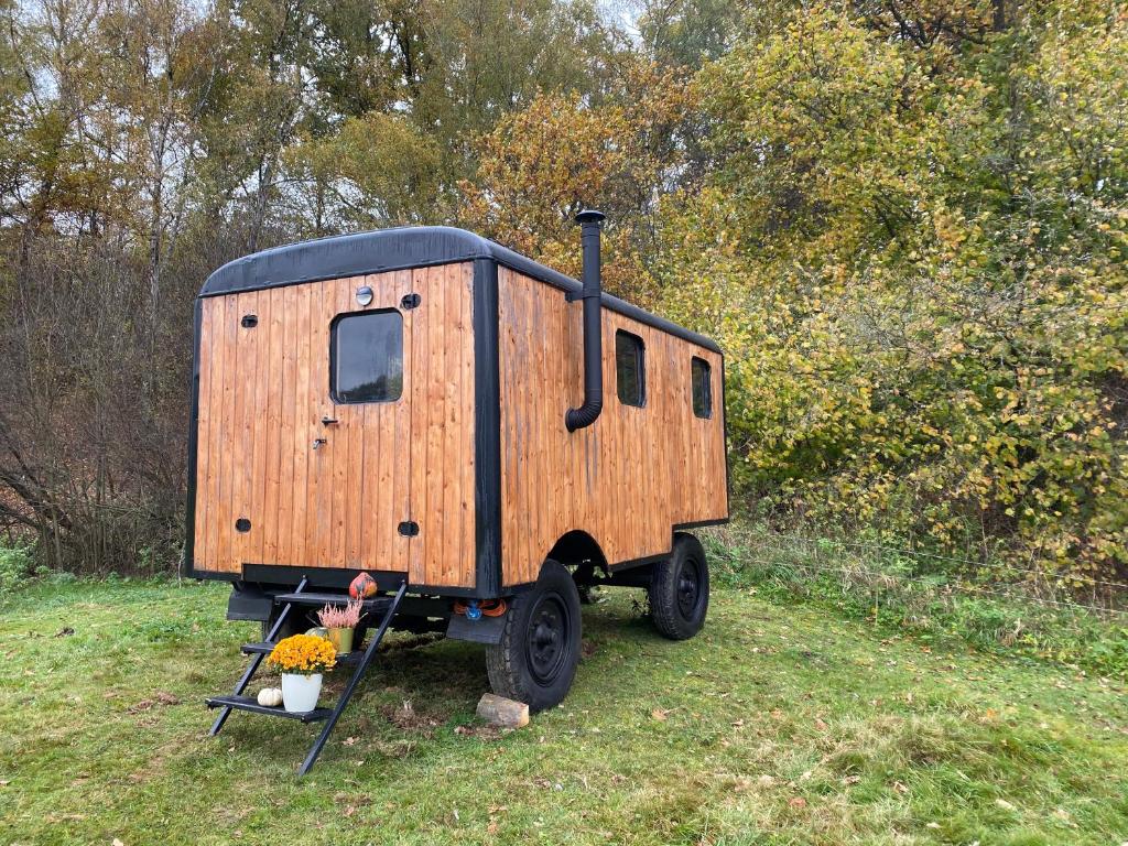 a small wooden trailer sitting in a field at Maringotka Za humny in Rančířov
