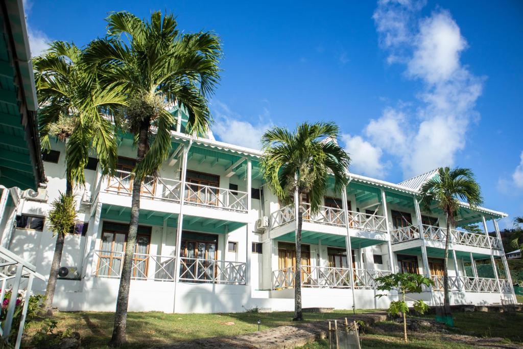 a building with palm trees in front of it at South West Bay Cabañas in Providencia