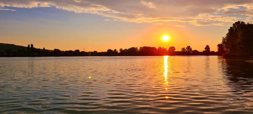 una puesta de sol sobre un gran cuerpo de agua en Palatinus Apartman Esztergom, en Esztergom