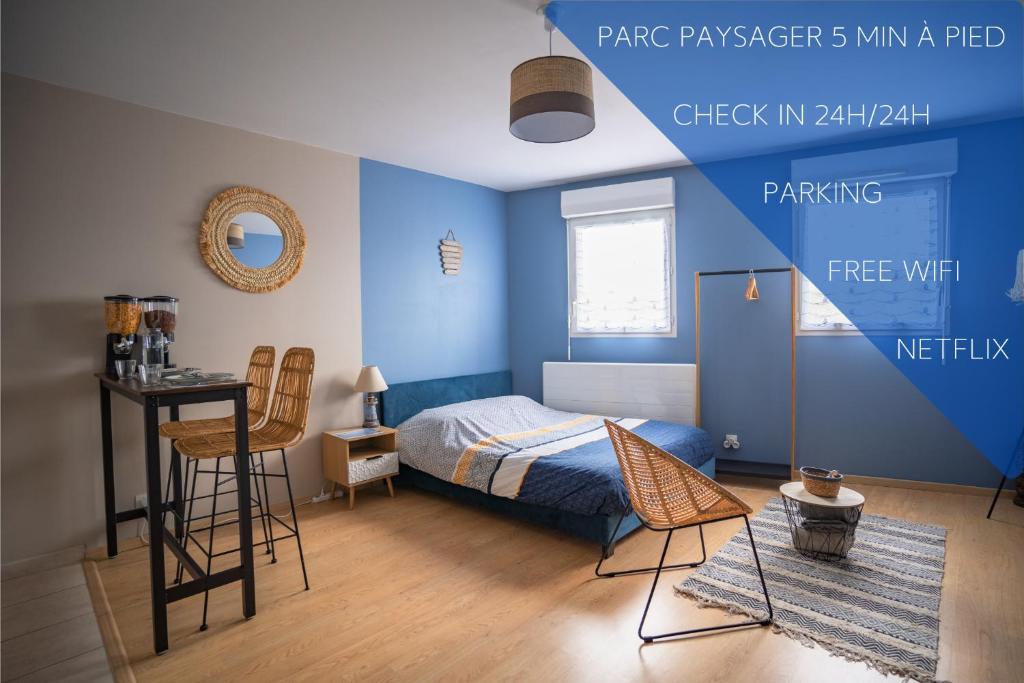 um quarto com paredes azuis, uma cama e uma mesa em L'Effet-Mer - Tout équipé - Parking Privé - Wifi em Saint-Nazaire