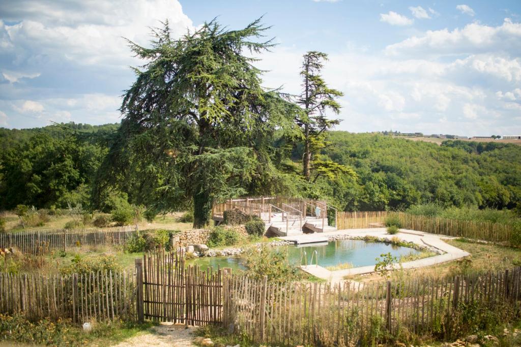 a pool in a yard with a fence at Le chant des pierres - douceur et nature in Les Marthres