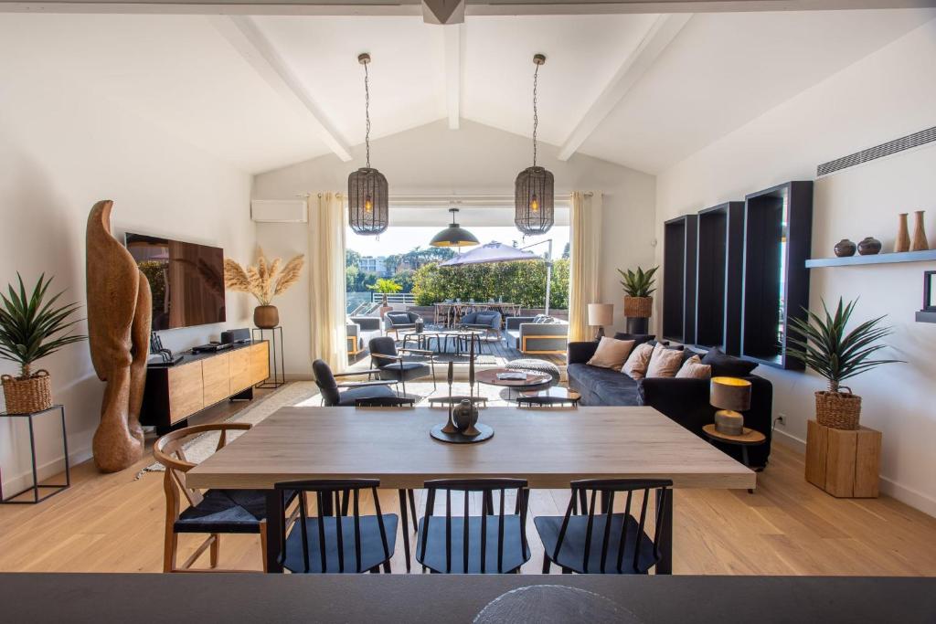 - un salon avec une grande table et des chaises en bois dans l'établissement HIBISCUS PENTHOUSE, à Cannes