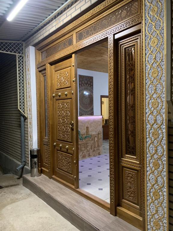 an entrance to a room with a wooden door at OLD SAFARI HOTEL make yourself at home in Bukhara