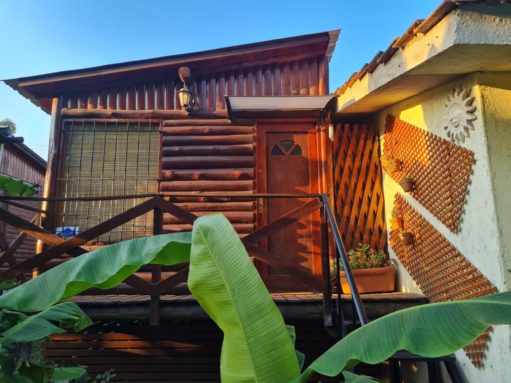 una casa de madera con una planta delante en Cabaña Alma 2 en Villa Carlos Paz