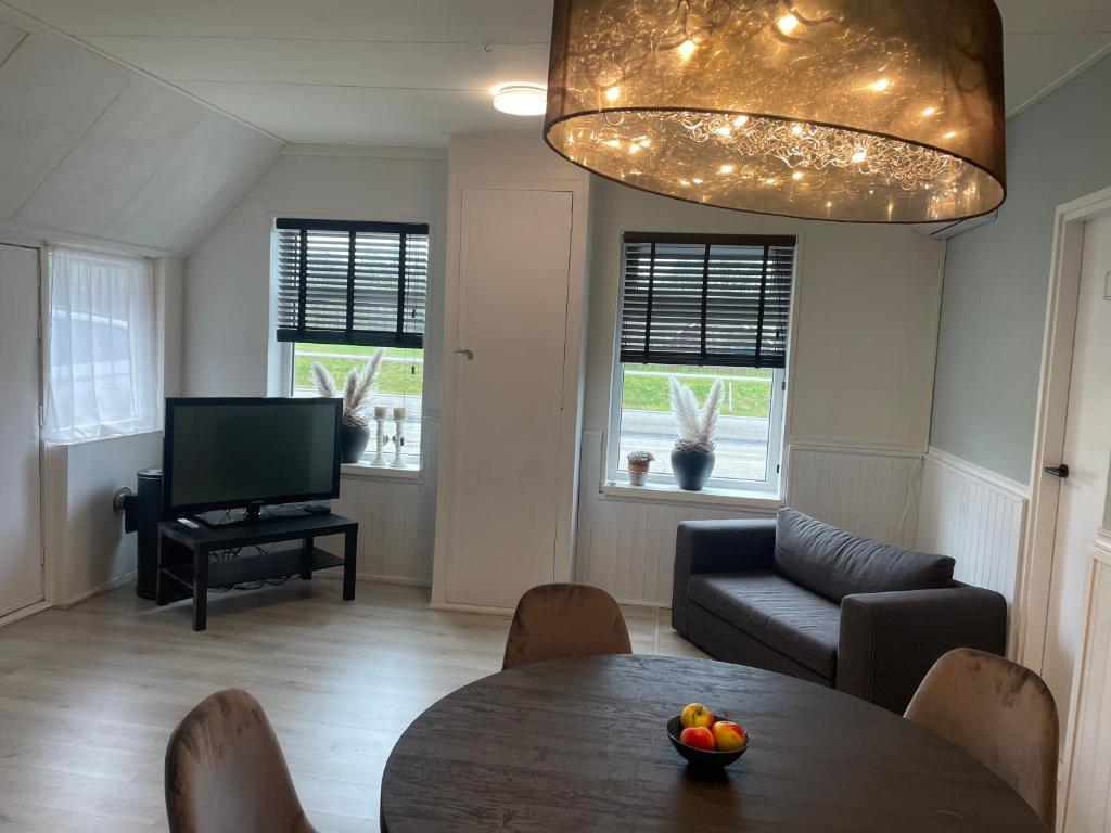 a living room with a table and a television at Appelscha aan de diek in Appelscha