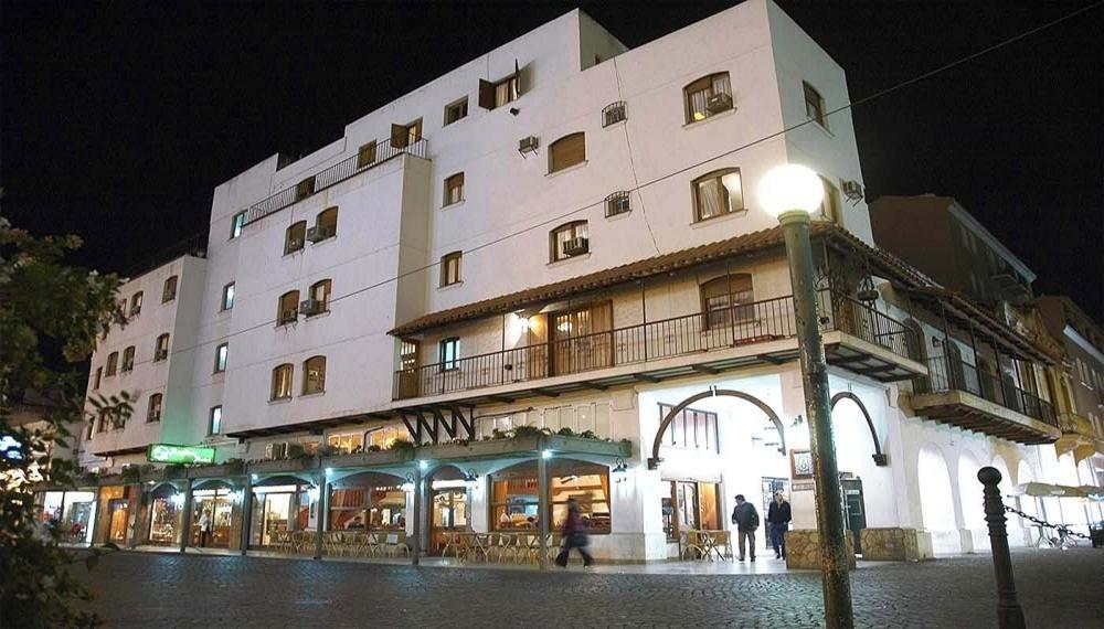 un gran edificio con gente de pie fuera de él por la noche en Hotel Regidor en Salta