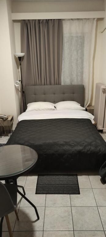 1 dormitorio con 1 cama grande y 1 mesa en El Greco, en Patra