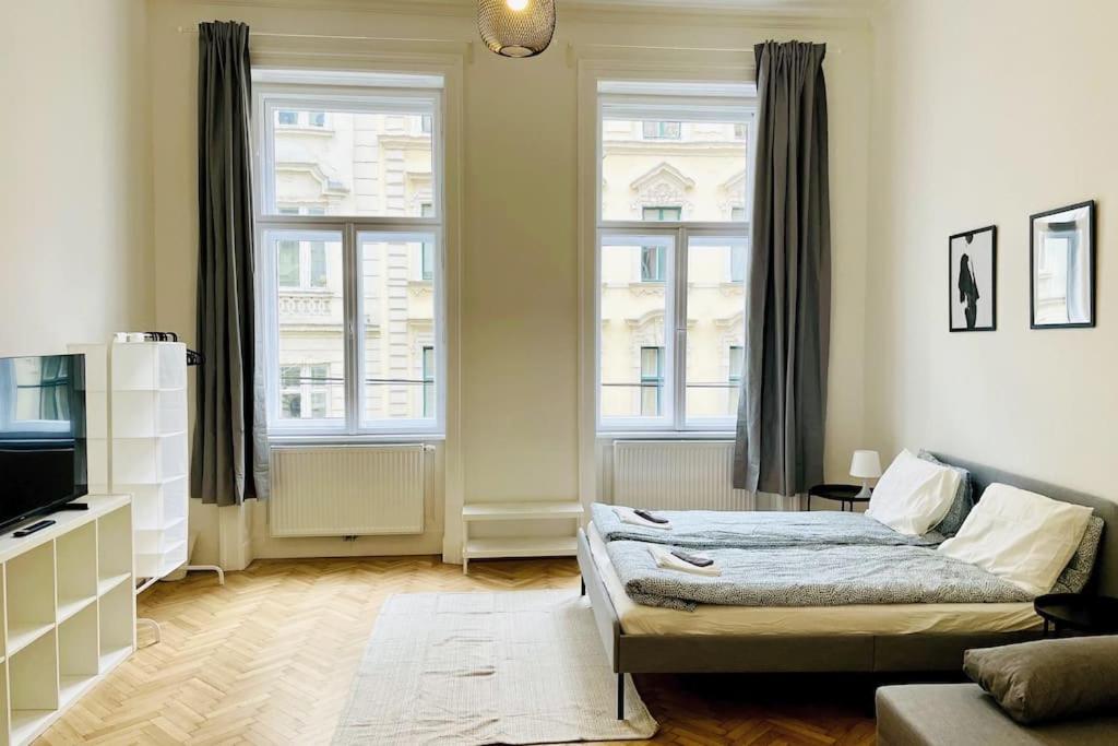 un soggiorno con un letto e due finestre di City-Center-Apartment Hip Area, Big & New a Vienna