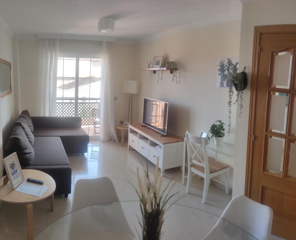salon z kanapą i stołem z telewizorem w obiekcie Benalmadena Beach Apartamento con Vistas al mar y Parking Privado Incluido w mieście Benalmádena