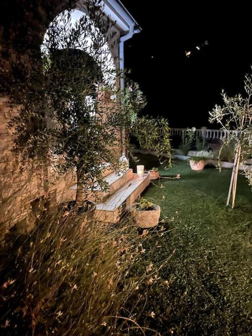 a stone building with a bench in a yard at night at Casa Fumica Studio in Kampor
