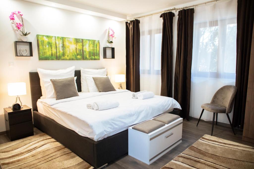 1 dormitorio con 1 cama grande y 1 silla en Nyuszis Apartman en Kiskunmajsa