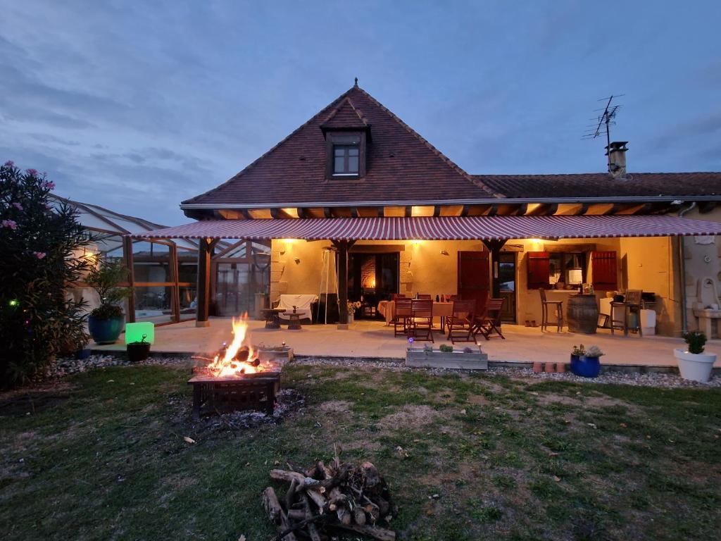 una casa con una hoguera en el patio en GITE à BOISSE près d'ISSIGEAC 24560 DORDOGNE en Boisse