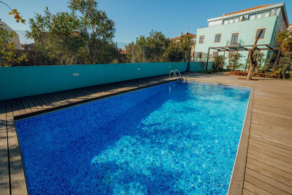 een groot blauw zwembad naast een gebouw bij Oporto Pool Apartment by Vacationy in Porto