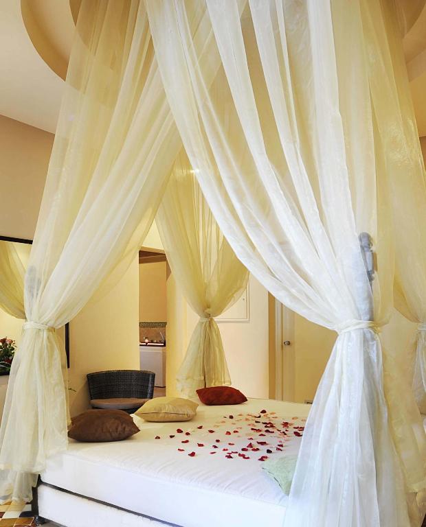 a bedroom with a white bed with a canopy at Berbère Palace in Ouarzazate