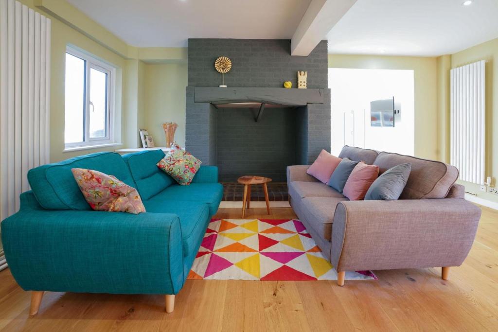 a living room with a blue couch and a chair at Unique 5BD Farm House Perfect for Relaxing in Ipswich