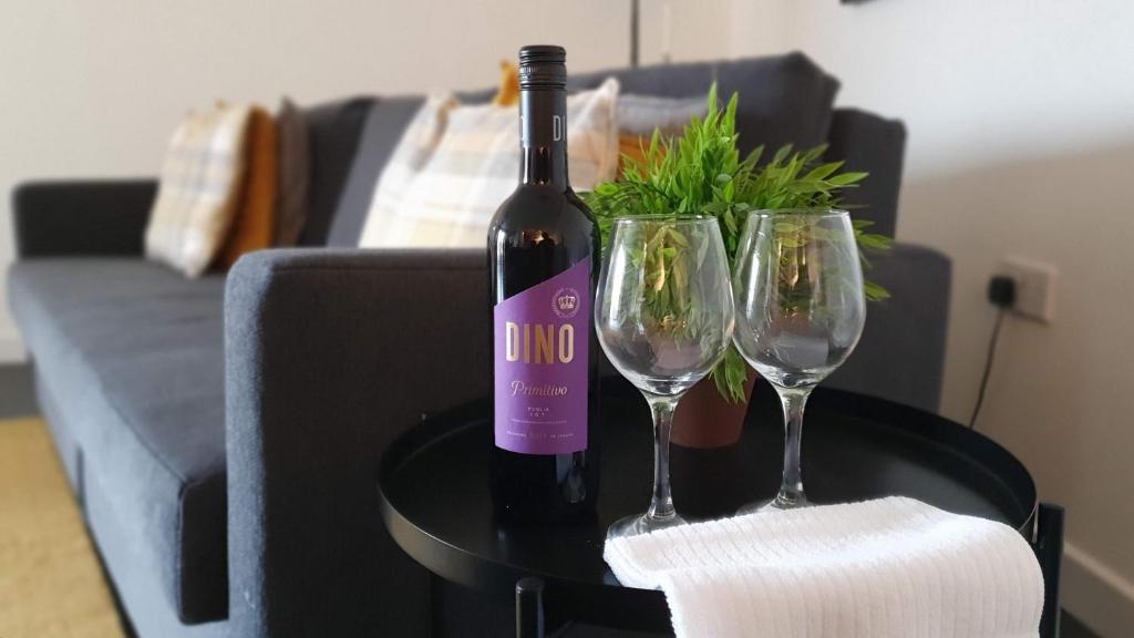 a bottle of wine and two wine glasses on a table at Spacious London apartment 5 min walk to Leytonstone Underground Station and 5 stops to zone 1 in London