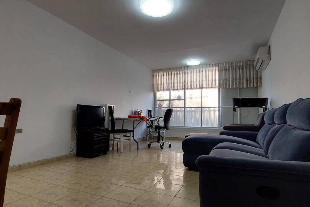 a living room with a couch and a table with chairs at הנביאים 1 נתניה Naveim apartment in Netanya