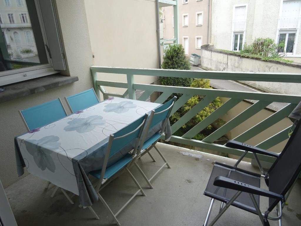 une table et des chaises assises sur un balcon dans l'établissement Le cocon de Garrigou, à Luchon