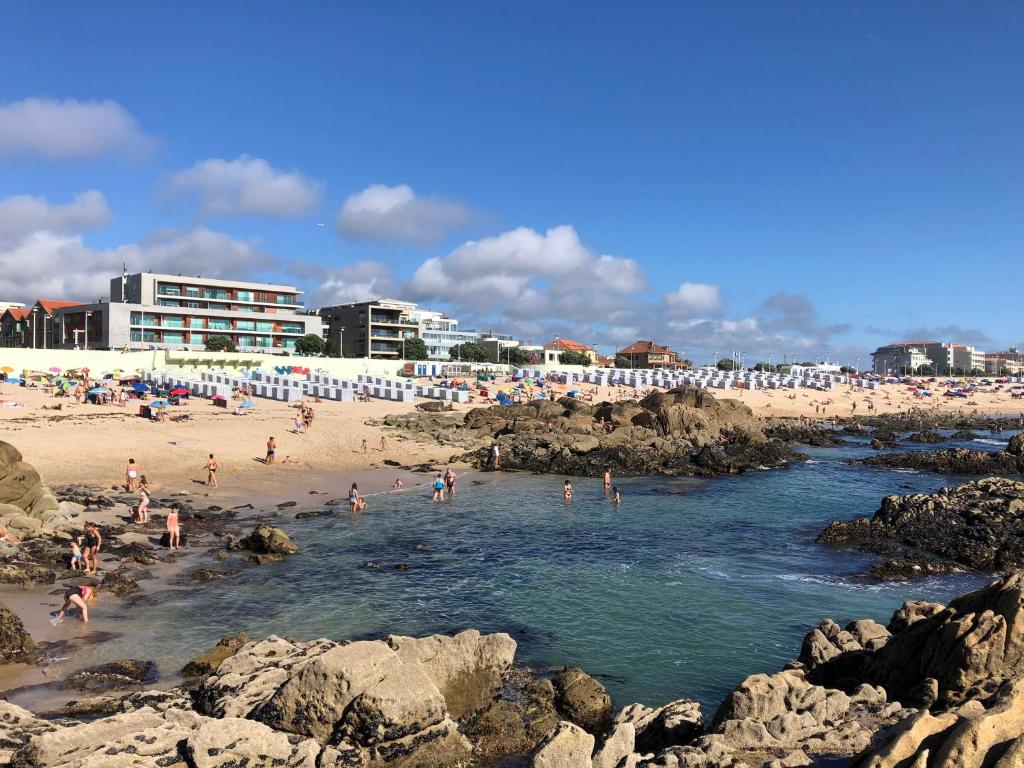 a group of people swimming in the water at a beach at Villa CL in Vila do Conde