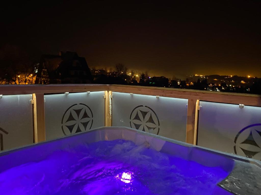 a hot tub on a balcony at night at Leśny Wierch in Bukowina Tatrzańska