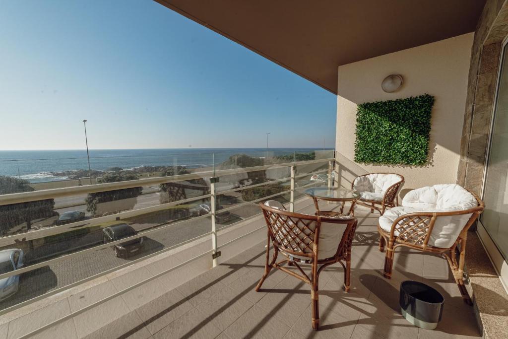 balcón con sillas, mesa y vistas al océano en Modern Grand Seaside & Seaview by Vacationy en Matosinhos