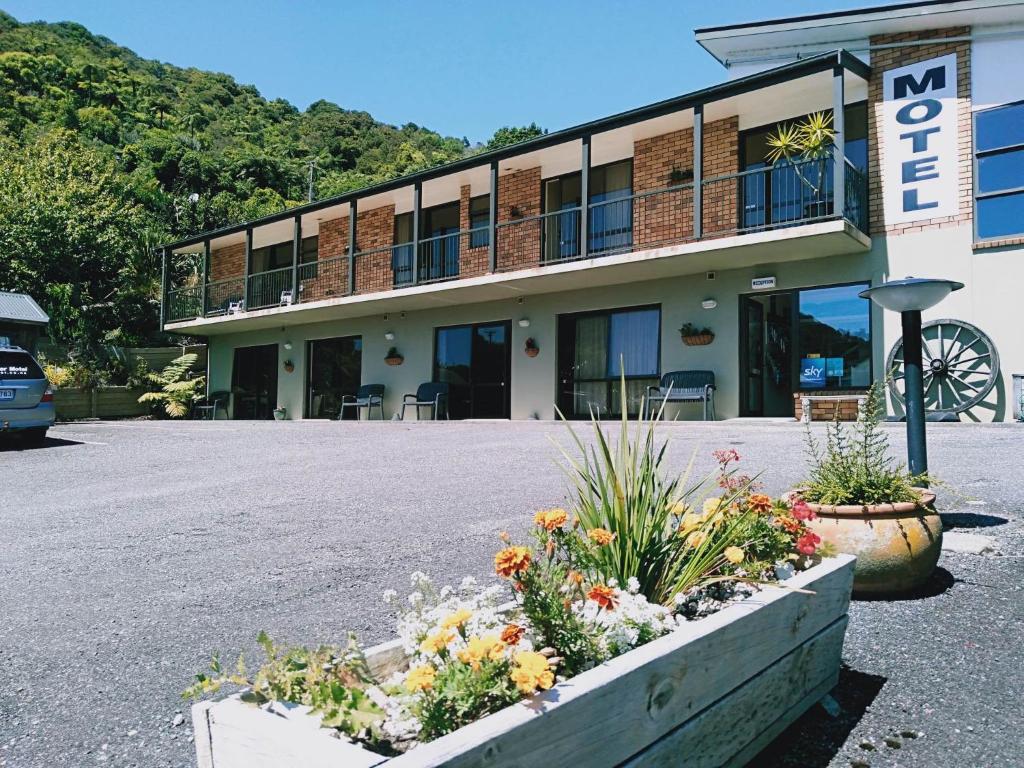 a building with flowers in front of it at Sundowner Motel in Greymouth