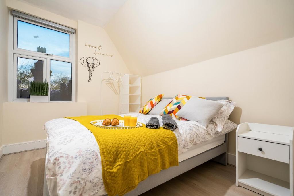 um quarto com uma cama com um cobertor amarelo em Deluxe 2-Bedroom Flat with Free parking em Birmingham