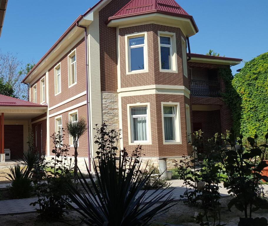 une grande maison en briques avec un toit rouge dans l'établissement House4you, à Tachkent