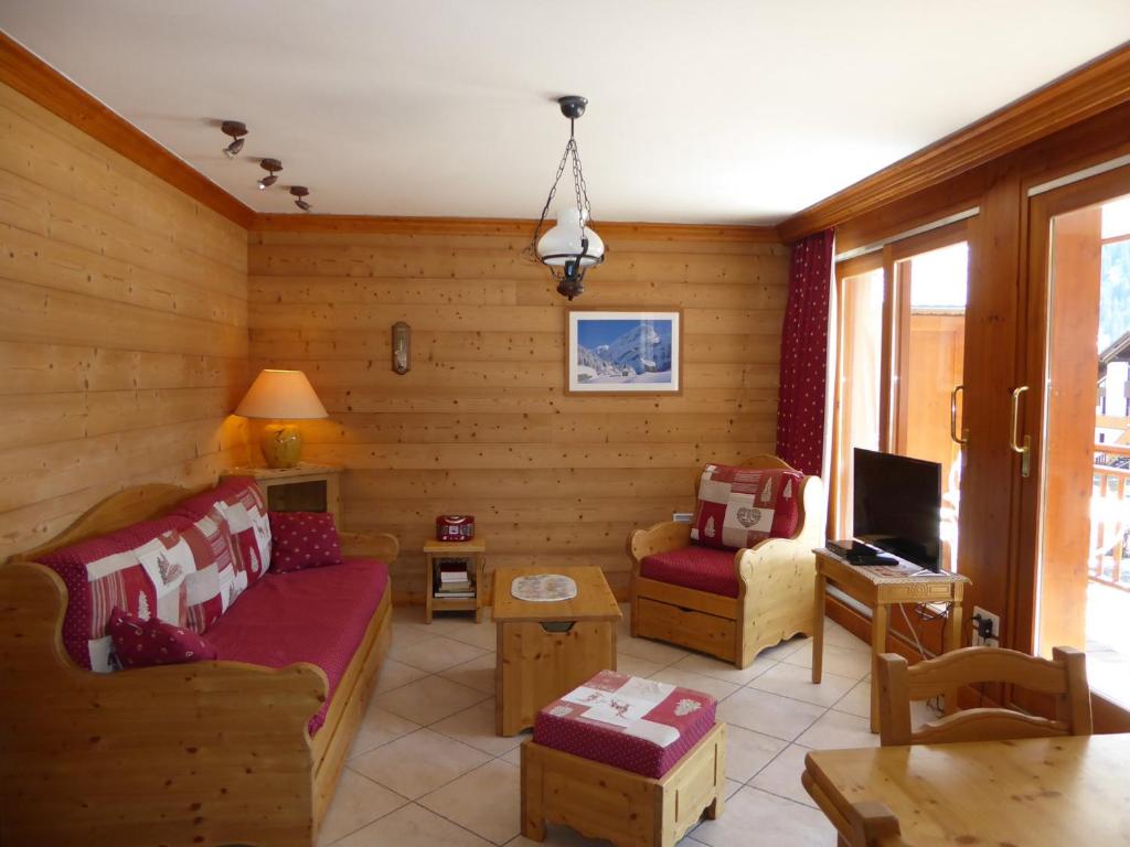 een woonkamer met een bank en een tv bij Appartement Pralognan-la-Vanoise, 3 pièces, 6 personnes - FR-1-464-67 in Pralognan-la-Vanoise
