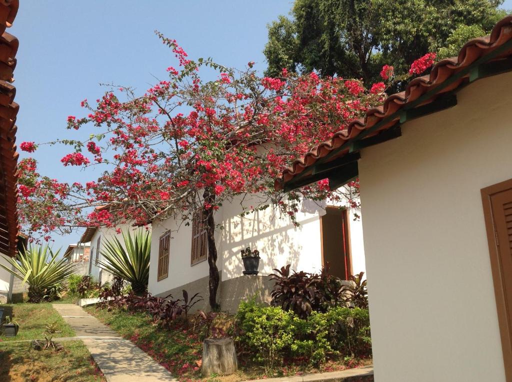 une maison avec des fleurs roses sur son côté dans l'établissement Maison Clapp, à Penedo