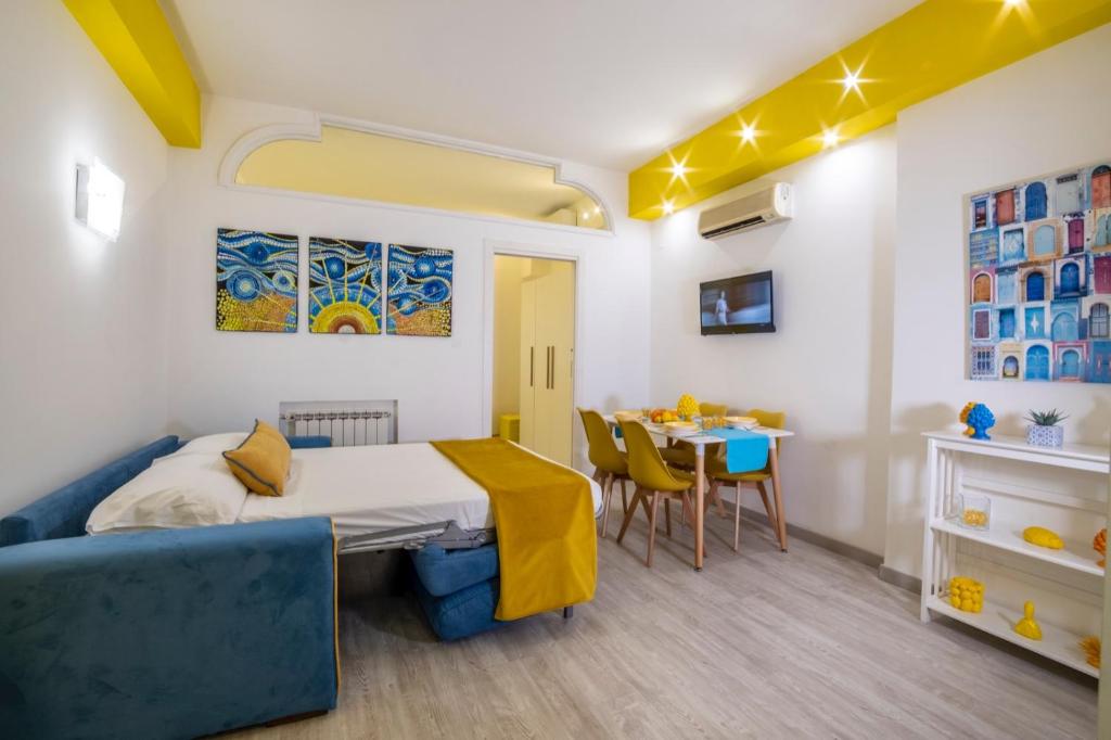 1 dormitorio con cama y mesa de comedor en Happy Flat free parking, en Sorrento